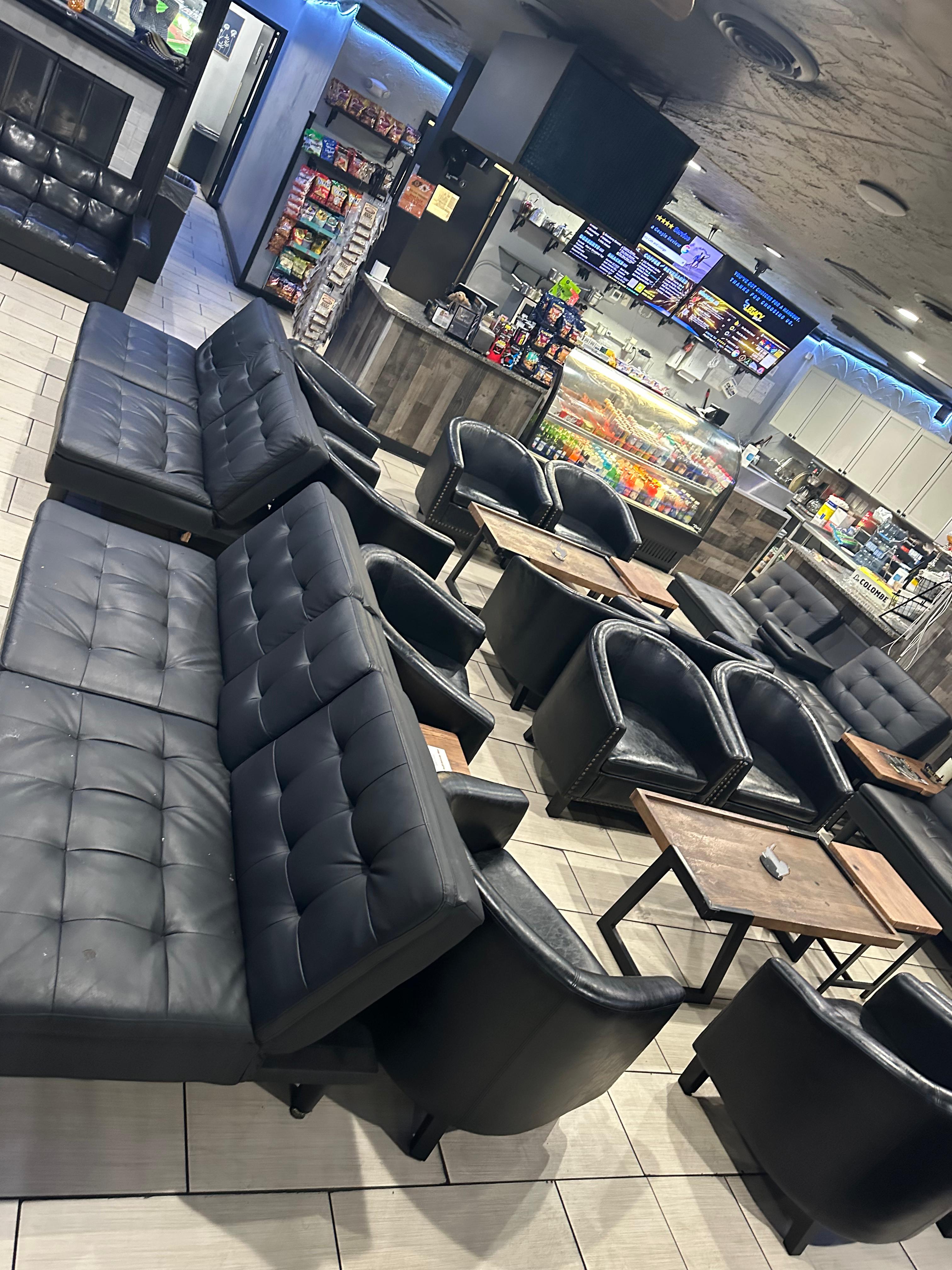 Legacy Cafe lounge seating with black sofas, armchairs, and wood tables